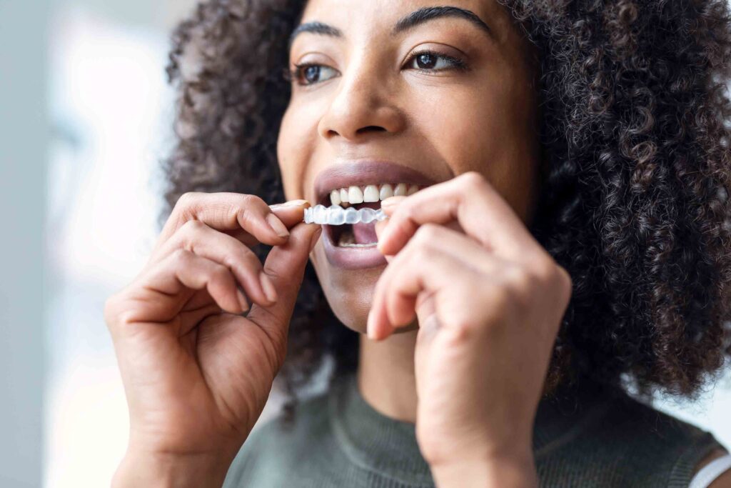 Close-up of woman wearing orthodontic silicone trainer. Invisible braces aligner.